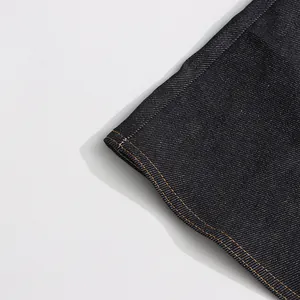 Gedetailleerd macrozicht van donkere denim rok met oranje contrasterende stiksels