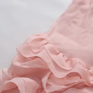 Nahaufnahme eines rosa Chiffonkleides mit Volant-Design und weicher Textur