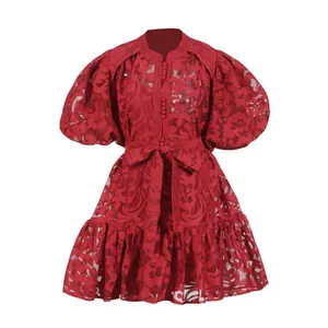 Detailed view of a red lace hollow-out dress featuring puff sleeves and belted waistline.
