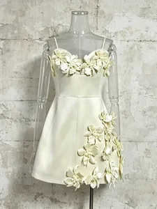 Elegant cream mini dress with 3D floral accents, spaghetti straps and A-line silhouette.