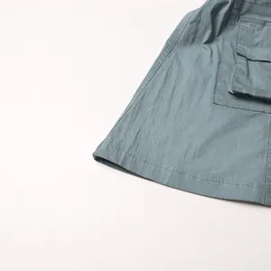 Primo piano dettagliato di una tasca cargo con patta su pantaloni cargo blu grigio.