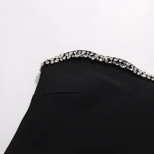 Close-up detail of sparkling rhinestone embellishments on an elegant black strapless top