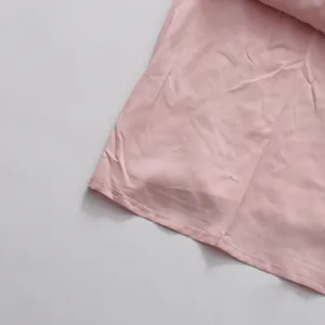 Detailaufnahme eines zartrosa Sommerkleidersaums mit einfacher Naht und feiner Stoffstruktur