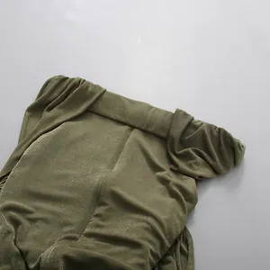 Close-up of the green ruched off-the-shoulder dress showing the textured fabric detail
