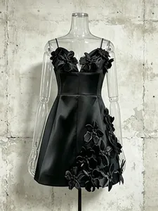 Black A-line mini dress with spaghetti straps and 3D floral applique on satin fabric.