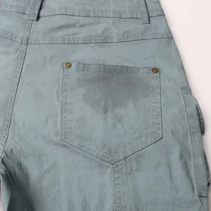Primo piano della tasca posteriore di pantaloni cargo azzurro lavato vintage con rivetti.