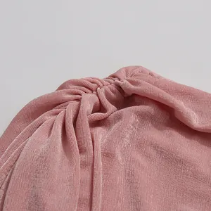 Close-up of ruched detail and textured pink fabric on an elegant summer bodycon dress.