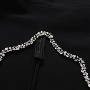 Close-up of sparkling rhinestone trim and invisible zipper on black elegant evening dress