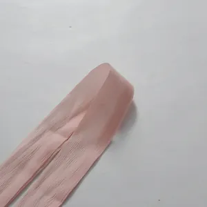 Makroaufnahme der zarten Textur des rosa plissierten Rüschenstoffdetails des Kleides.