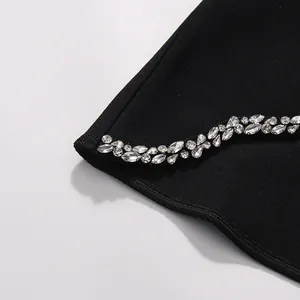 Detailed close-up showing intricate crystal beadwork on high-quality black rib-knit fabric edge