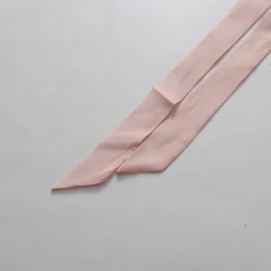 Nahaufnahme eines hellrosa gerafften Chiffon-Taillenbandes für ein Sommerkleid-Detail