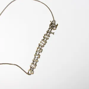 Primo piano di collana color bronzo con pendente nome BLAKE e strass scintillanti
