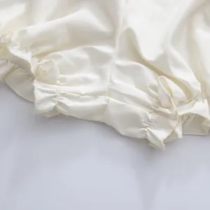 Nahaufnahme des weißen Rüschensaums an einem leichten Sommerkleid
