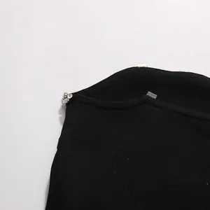 Close-up detail of a black strapless top featuring exquisite crystal beading and knit texture