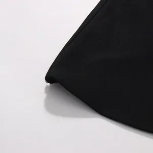 Detailed view of the high-quality black textured fabric and fine beaded hem of the dress
