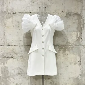Close-up of elegant white V-neck blazer dress featuring sheer puff sleeves and crystals