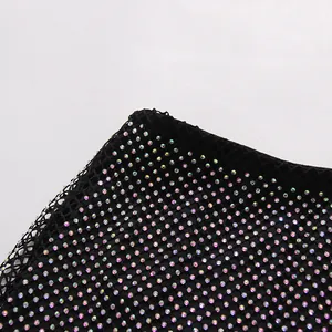 Macro detail view of black mesh fabric with iridescent rhinestones for evening dress set
