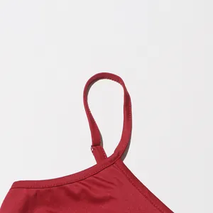 Close-up detail of the fine stitching and adjustable strap on a fashionable red dress