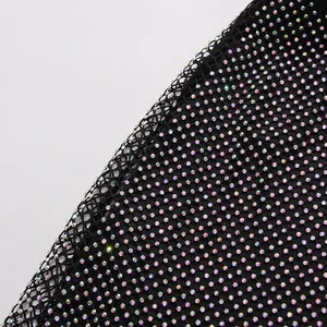 Close-up detail of black mesh fabric with iridescent rhinestones on a French style dress