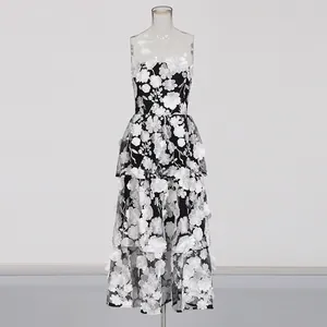 Detail view of elegant strapless dress with white 3D floral embroidery on black mesh