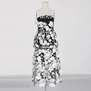 Detail view of the intricate white 3D floral embroidery on the black strapless long dress.