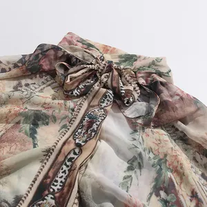 Dettaglio dello scollo dell'abito vintage in stile palazzo con fiocco e stampa floreale