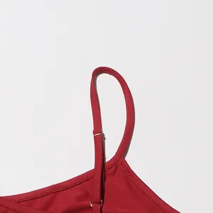 Close-up view of adjustable red shoulder strap with silver metal slider on fabric.