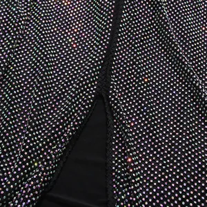 Detail view of black sequined evening skirt with sparkling rhinestones and side slit