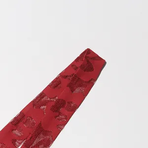 Close-up of red jacquard hollow-out fabric detailing a fashionable spring dress design.
