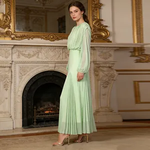 Elegant mint green pleated maxi dress with long sleeves in a luxurious vintage indoor room
