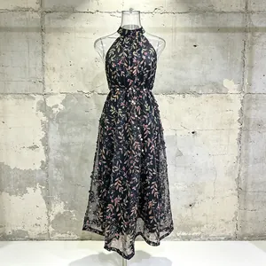 Robe longue fleurie à licou, sans manches, taille marquée avec détails de perles.