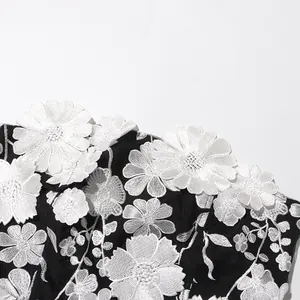 Close-up detail of white 3D floral embroidery on a black elegant tube top long dress