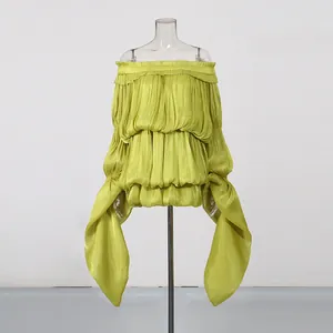 Detailed view of lime green off-shoulder resort dress with pleated texture and long ribbons