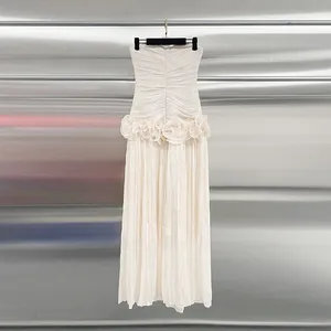 Elegant champagne strapless maxi dress with ruffled waist and refined pleated fabric detail