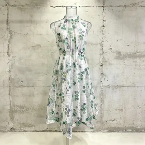 Vue détaillée d'une robe d'été sans manches à imprimés floraux verts et ourlet irrégulier