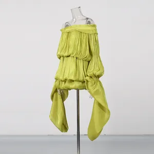 Detailed view of lime green ruffled off-shoulder dress with long flowing ribbons.