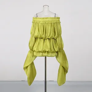 Detail of lime green off-the-shoulder dress with pleats and flowing ruffle sleeves
