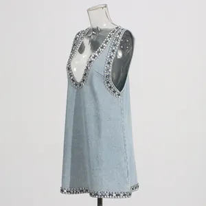Vista dettagliata di un abito in denim blu chiaro con strass pesanti sullo scollo a V