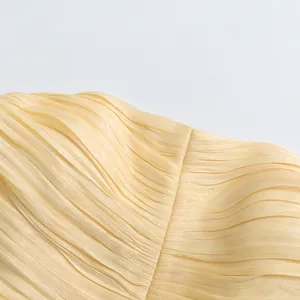 Detail shot of elegant cream pleated fabric with fine stitching for women dress
