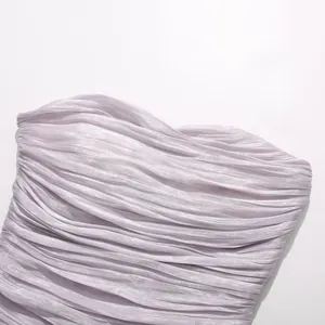 Close-up detail of lavender pleated fabric on a summer party dress with soft metallic sheen