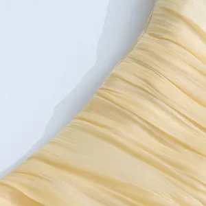 Detailed macro view showing the champagne ruched fabric texture of an elegant long dress