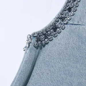Primo piano con pesanti decorazioni in strass scintillanti su un abito in denim celeste