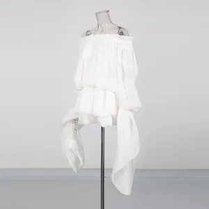 Detail view of white off-the-shoulder tiered ruffled mini dress with long streamer sashes