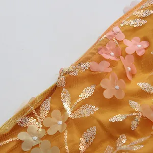 Détail de robe d'été jaune avec appliques florales 3D et broderies de paillettes
