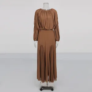 Detail of brown long-sleeved pleated maxi dress with elegant round neck design.