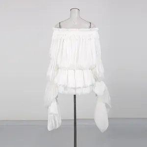 Detailed view of white off-shoulder pleated mini dress with ruffled hem and flared sleeves