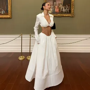 Detail shot of an elegant white two-piece set with V-neck cropped top and long maxi skirt.