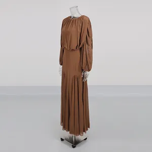 Side view of a brown pleated long-sleeved dress with a round neckline and maxi length.