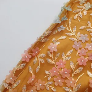 Gros plan d'appliques florales 3D roses et de paillettes dorées sur tulle jaune