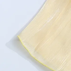 Detail of shimmering light yellow sheer fabric with a delicate rolled hemline finish.